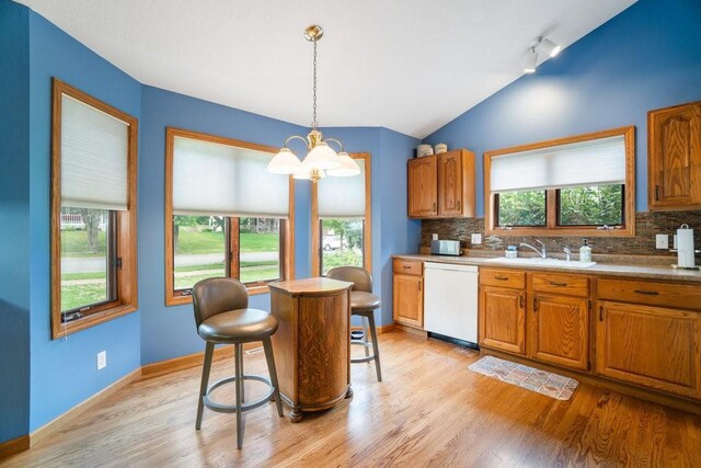 4129 Birch Crest Ln, Eau Claire, WI 54701 - kitchen featuring white dishwasher, a chandelier, light wood finished floors, decorative backsplash, and lofted ceiling