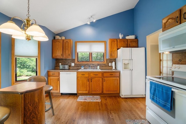 4129 Birch Crest Ln, Eau Claire, WI 54701 - kitchen featuring white appliances, lofted ceiling, backsplash, a chandelier, and light wood finished floors