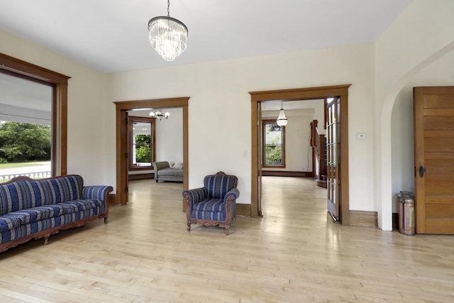 205 W Main St, Weyauwega, WI 54983 - living room featuring a chandelier, arched walkways, and light wood-style flooring