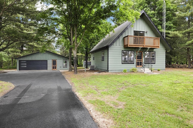 W2726 Marion St, Neshkoro, WI 54960 - view of front of house with a balcony, a detached garage, an outdoor structure, a front yard, and board and batten siding