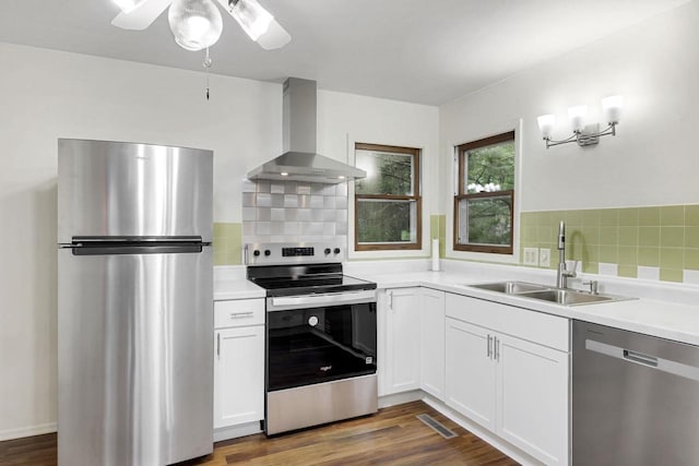 W2726 Marion St, Neshkoro, WI 54960 - kitchen with stainless steel appliances, wall chimney exhaust hood, white cabinets, light countertops, and dark wood-style flooring