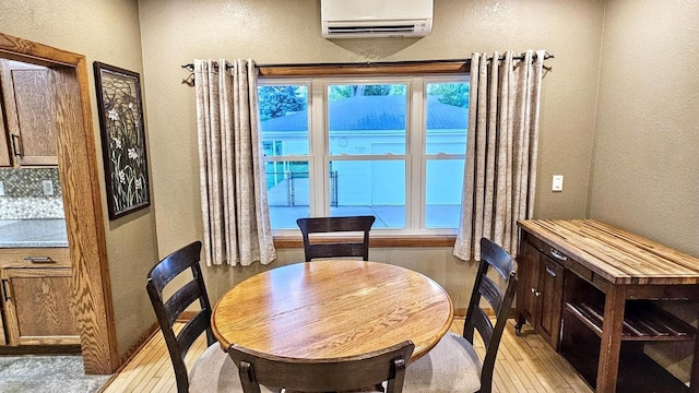 553 W 17th Ave, Oshkosh, WI 54902 - dining room with a textured wall, a wall unit AC, light wood-type flooring, and healthy amount of natural light