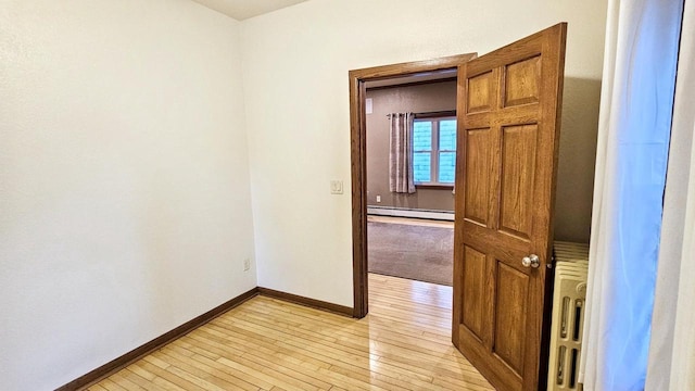 553 W 17th Ave, Oshkosh, WI 54902 - unfurnished room with a baseboard radiator and light wood-style floors