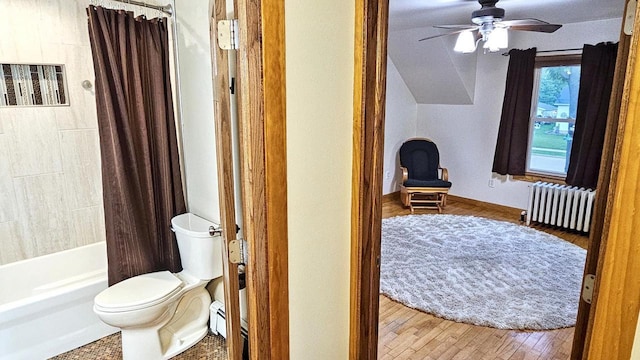 553 W 17th Ave, Oshkosh, WI 54902 - bathroom featuring radiator, ceiling fan, wood finished floors, shower / bath combo, and vaulted ceiling