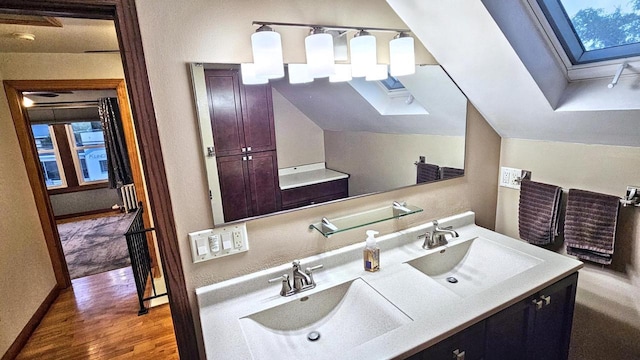 553 W 17th Ave, Oshkosh, WI 54902 - bathroom featuring a skylight, double vanity, and wood finished floors