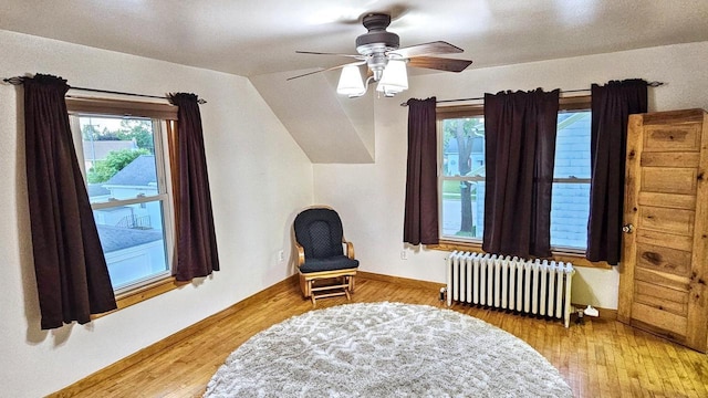 553 W 17th Ave, Oshkosh, WI 54902 - sitting room featuring radiator heating unit, wood finished floors, vaulted ceiling, and a ceiling fan