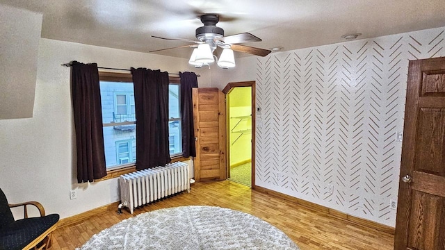 553 W 17th Ave, Oshkosh, WI 54902 - bedroom featuring radiator heating unit, light wood-style floors, a ceiling fan, and ensuite bath