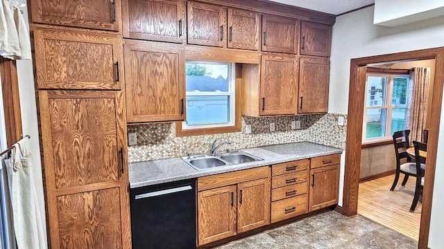 553 W 17th Ave, Oshkosh, WI 54902 - kitchen featuring black dishwasher, tasteful backsplash, light countertops, and brown cabinetry