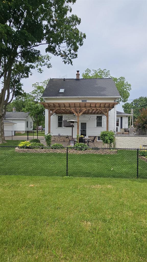 553 W 17th Ave, Oshkosh, WI 54902 - rear view of property featuring a pergola and a chimney