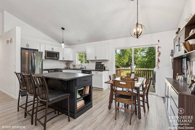W1018 Larkspur Rd, Genoa City, WI 53128 - kitchen with open shelves, dark countertops, vaulted ceiling, stainless steel appliances, and white cabinets