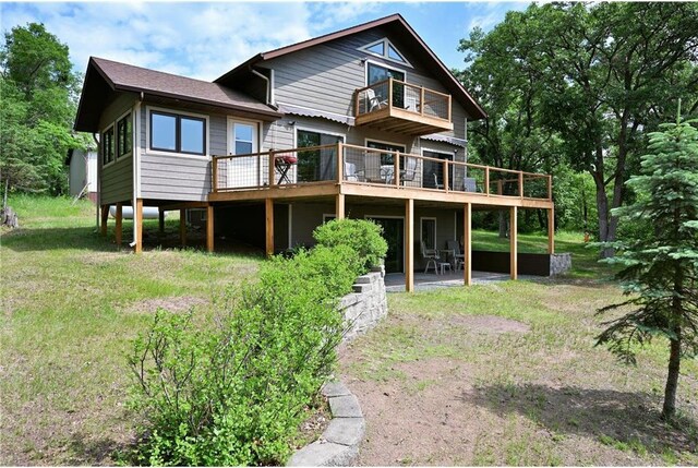 33516 No Mans Trl, Minong, WI 54859 - back of house featuring a balcony, a wooden deck, a yard, and a patio area