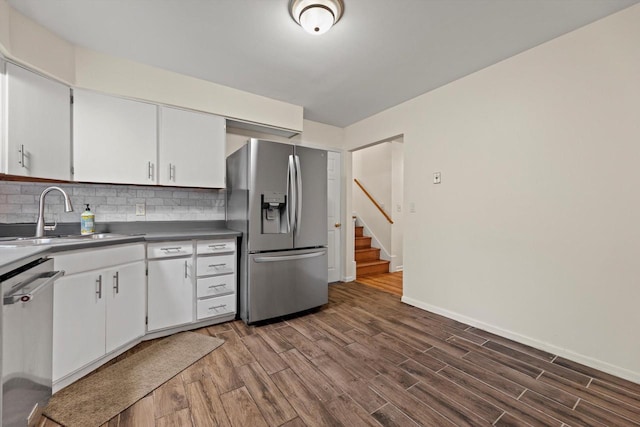 8088 N 65th St, Brown Deer, WI 53223 - kitchen with stainless steel appliances, decorative backsplash, dark countertops, and white cabinets
