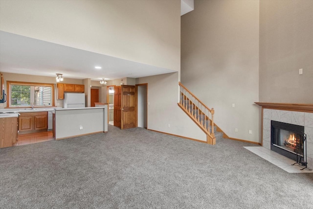 2975 River Birch Dr Unit F, Brookfield, WI 53045 - unfurnished living room featuring light carpet, stairs, a fireplace, and a high ceiling