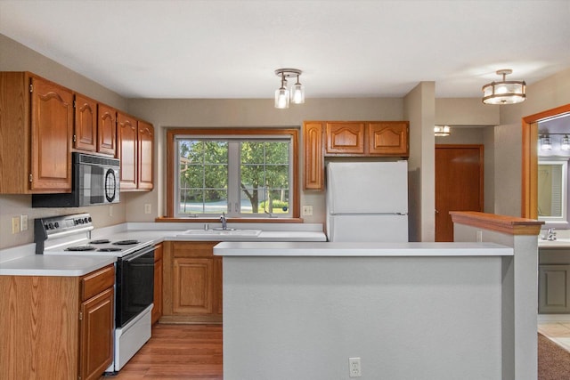 2975 River Birch Dr Unit F, Brookfield, WI 53045 - kitchen with white appliances, light countertops, light wood-style flooring, and brown cabinetry