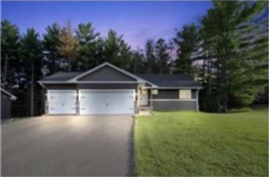316 Evergreen Dr, Somerset, WI 54025 - ranch-style house featuring asphalt driveway, a front lawn, and an attached garage