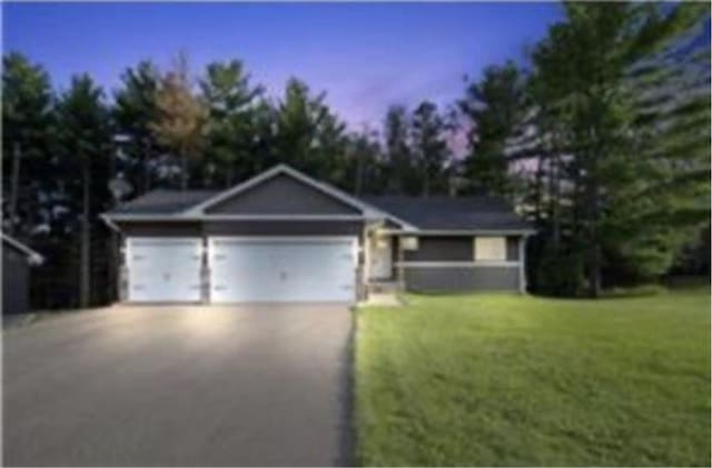 316 Evergreen Dr, Somerset, WI 54025 - ranch-style house featuring asphalt driveway, a front lawn, and an attached garage