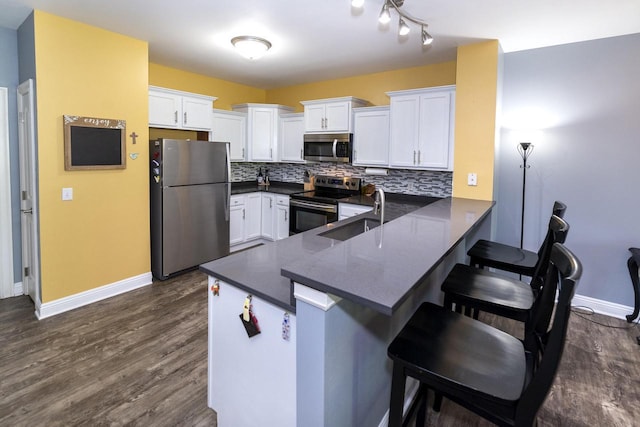 N165W20576 Berry Patch Rd Unit 702, Jackson, WI 53037 - kitchen featuring appliances with stainless steel finishes, dark countertops, a peninsula, and white cabinets