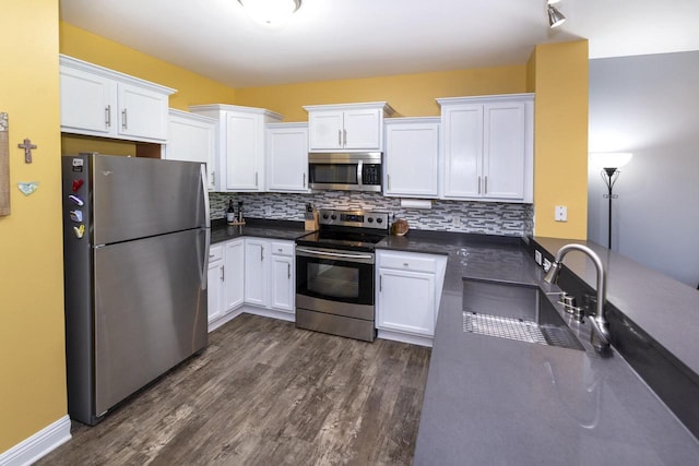 N165W20576 Berry Patch Rd Unit 702, Jackson, WI 53037 - kitchen with stainless steel appliances, dark countertops, white cabinets, and dark wood finished floors