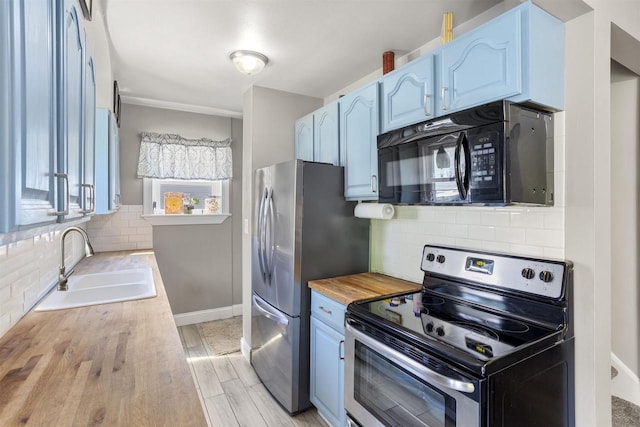 902 E Fremont St, Appleton, WI 54915 - kitchen with stainless steel appliances, tasteful backsplash, wood counters, and blue cabinets