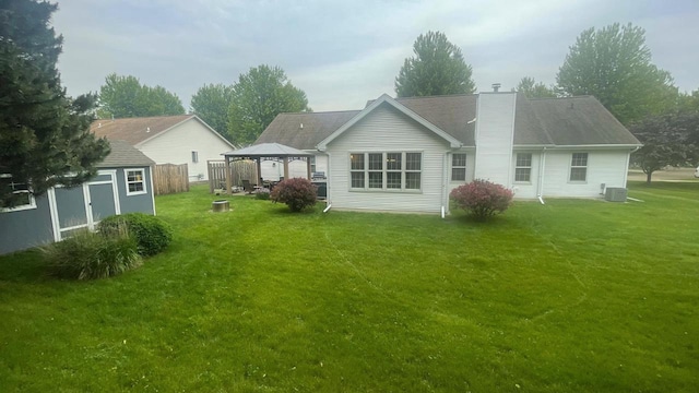 22 Weatherstone Dr, Appleton, WI 54914 - back of house featuring a gazebo, a storage unit, a lawn, and a chimney