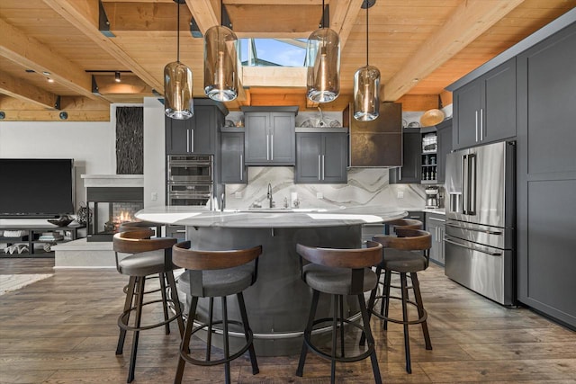 N52W35002 Lake Dr Unit 302, Okauchee, WI 53069 - kitchen with stainless steel appliances, a wooden ceiling with exposed beams, light countertops, dark wood finished floors, and tasteful backsplash