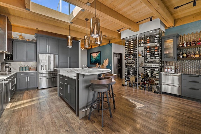 N52W35002 Lake Dr Unit 302, Okauchee, WI 53069 - kitchen with stainless steel fridge, a wood ceiling with exposed beams, gray cabinetry, a skylight, and dark wood-style floors