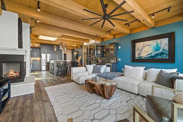 N52W35002 Lake Dr Unit 302, Okauchee, WI 53069 - living room with a wood ceiling with exposed beams, dark wood-style floors, track lighting, a ceiling fan, and a multi sided fireplace