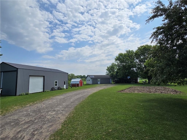 N35182 Weverstad Rd, Blair, WI 54616 - view of grassy yard with a garage, an outbuilding, and driveway