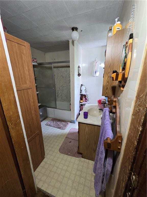 N35182 Weverstad Rd, Blair, WI 54616 - bathroom featuring vanity, bath / shower combo with glass door, and tile patterned floors