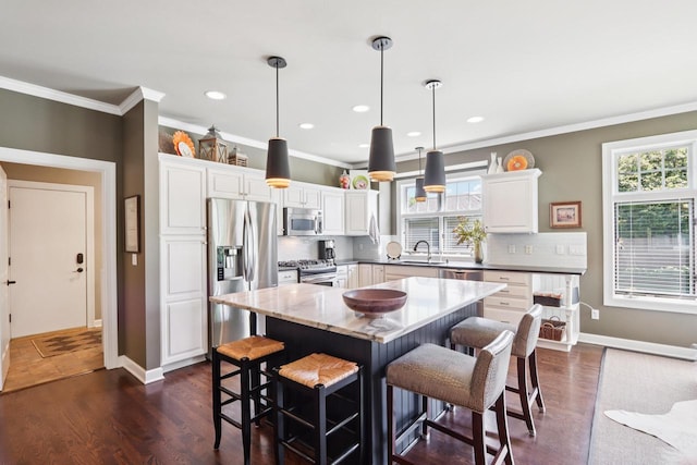 16885 Lake Rd Unit A, Brookfield, WI 53005 - kitchen with appliances with stainless steel finishes, white cabinetry, decorative backsplash, ornamental molding, and a breakfast bar