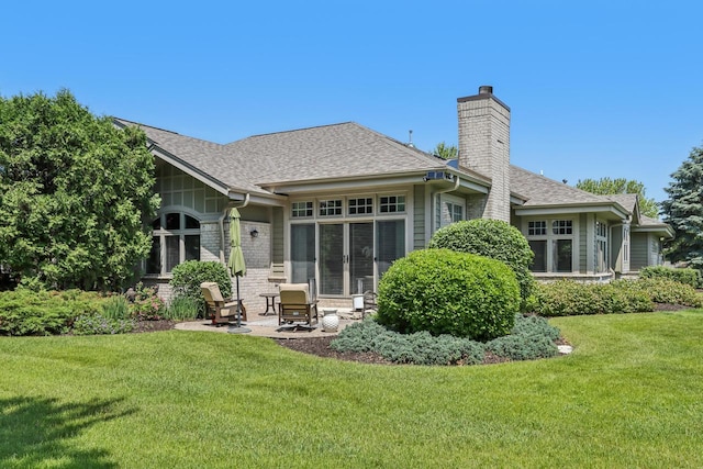 16885 Lake Rd Unit A, Brookfield, WI 53005 - back of property with a chimney, a yard, a shingled roof, and brick siding