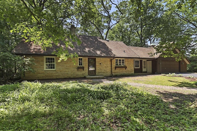3023 Bruce Dr, Racine, WI 53404 - view of front of home with stone siding, a garage, and a chimney