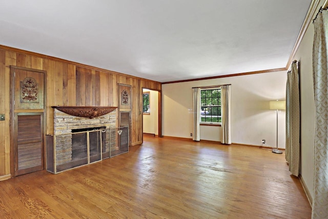3023 Bruce Dr, Racine, WI 53404 - unfurnished living room featuring ornamental molding, a fireplace, light wood-style floors, and wood walls