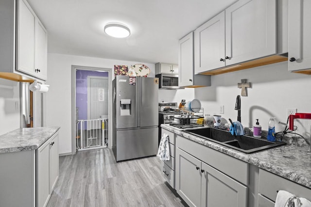 1329 Central St, Oshkosh, WI 54901 - kitchen with stainless steel appliances, light wood finished floors, light countertops, and white cabinets