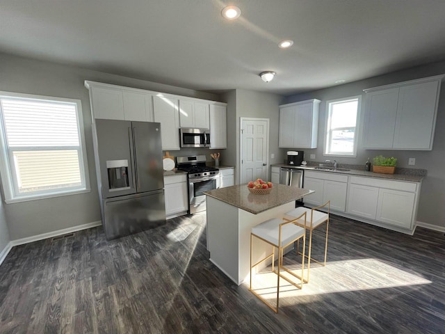 640 E Maple Beach Dr, Edgerton, WI 53534 - kitchen with stainless steel appliances, a center island, dark wood-type flooring, white cabinets, and recessed lighting