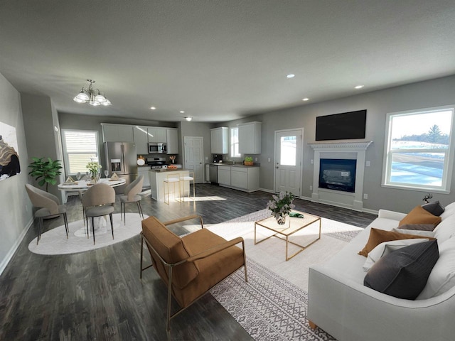 640 E Maple Beach Dr, Edgerton, WI 53534 - living room featuring a chandelier, a glass covered fireplace, dark wood finished floors, and recessed lighting