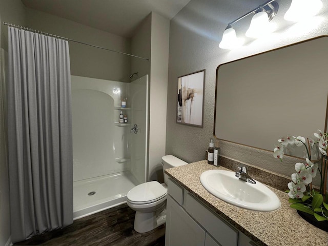640 E Maple Beach Dr, Edgerton, WI 53534 - full bathroom featuring wood finished floors, a shower with shower curtain, vanity, and a textured wall