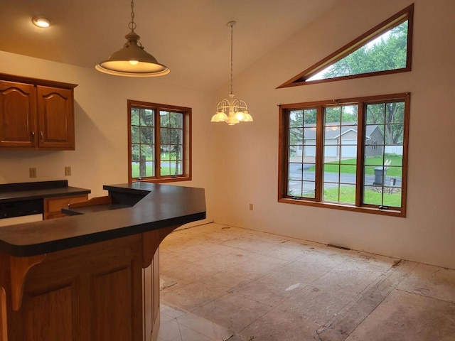 1607 E Cleveland St, Marshfield, WI 54449 - kitchen featuring dark countertops, a chandelier, pendant lighting, vaulted ceiling, and a center island