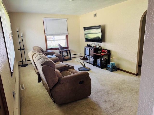 1117 21st St, Monroe, WI 53566 - living room featuring arched walkways, carpet flooring, a textured wall, and a baseboard radiator