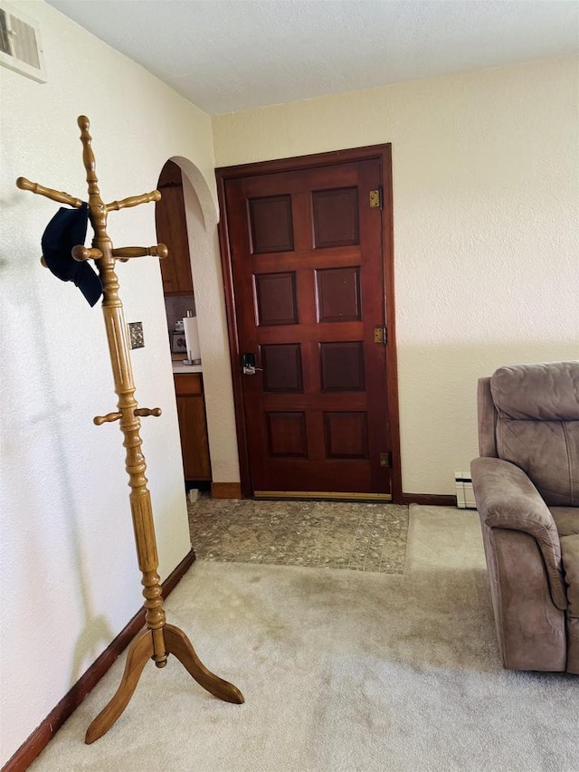 1117 21st St, Monroe, WI 53566 - entrance foyer with arched walkways, light carpet, and baseboard heating