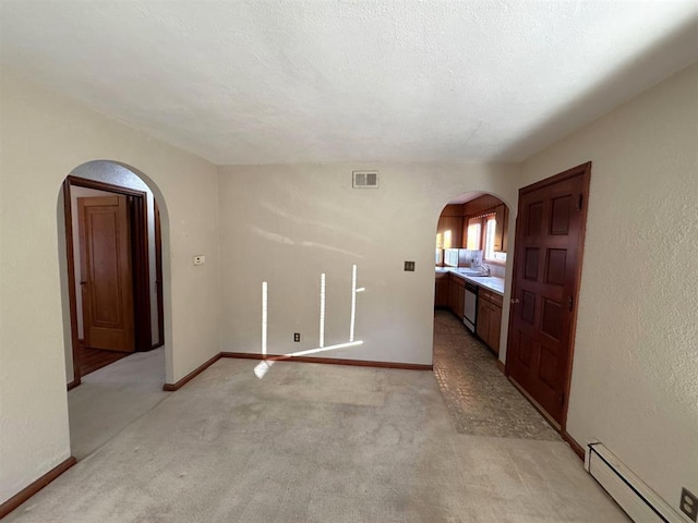 1117 21st St, Monroe, WI 53566 - spare room featuring a baseboard radiator, arched walkways, and light carpet
