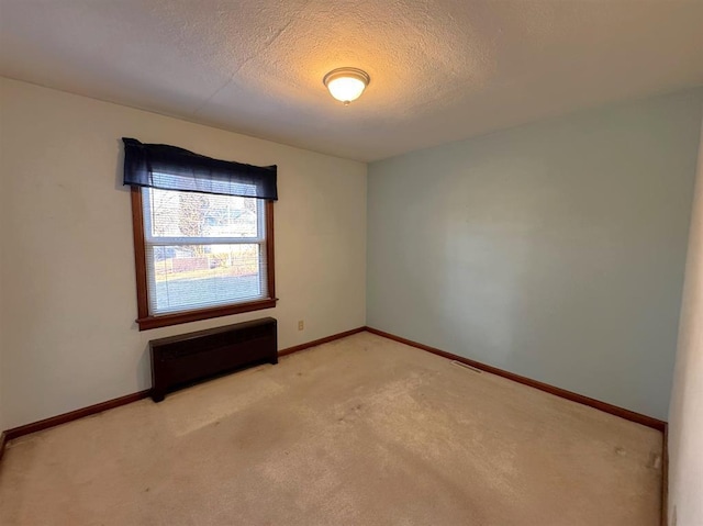1117 21st St, Monroe, WI 53566 - empty room featuring a textured ceiling, light carpet, and radiator