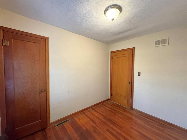 1117 21st St, Monroe, WI 53566 - spare room with wood finished floors and a textured ceiling