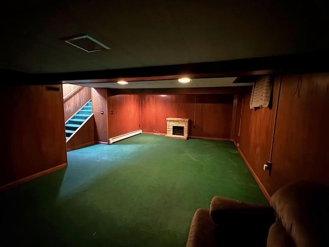 1117 21st St, Monroe, WI 53566 - finished basement featuring a baseboard heating unit, carpet, a fireplace, and wood walls