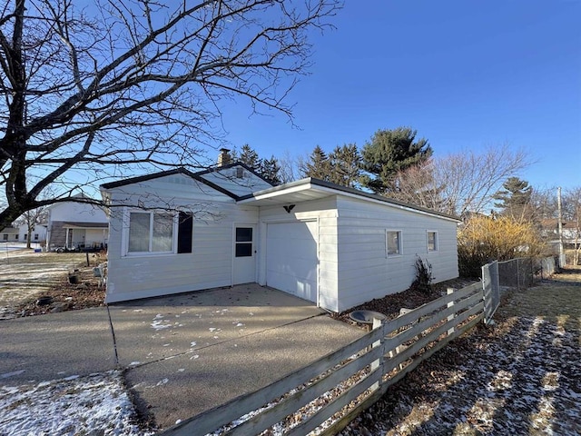 1117 21st St, Monroe, WI 53566 - view of side of home featuring a chimney, an attached garage, and concrete driveway