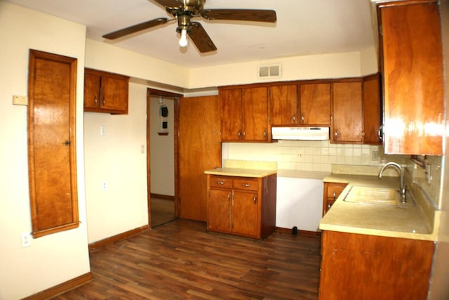 4228 N 52nd St, Milwaukee, WI 53216 - kitchen featuring under cabinet range hood, brown cabinetry, a ceiling fan, decorative backsplash, and dark wood finished floors