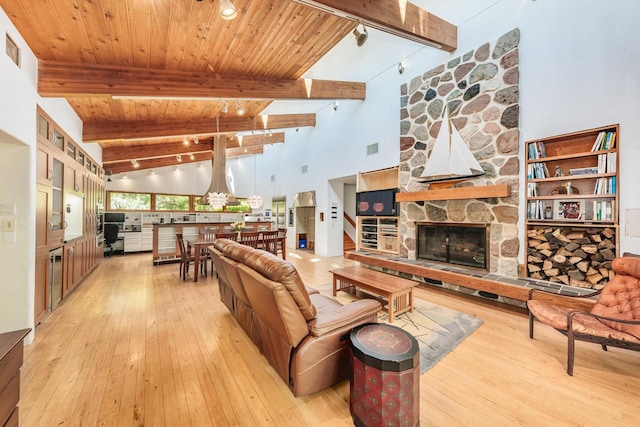 W296N2978 Franciscan Rd, Pewaukee, WI 53072 - living room featuring light wood-type flooring, a stone fireplace, high vaulted ceiling, and a wood ceiling with exposed beams