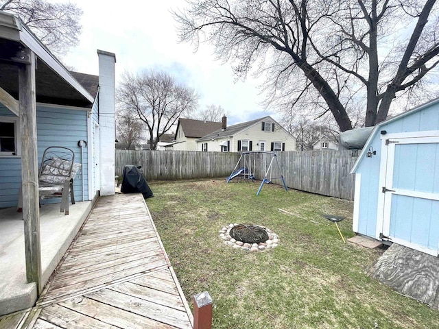 1116 Liberty Ave, Beloit, WI 53511 - fenced backyard with a playground, a storage shed, and an outdoor fire pit