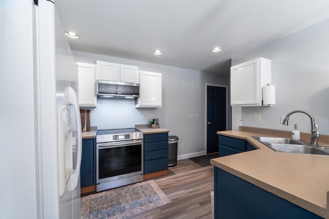 6615 Cavin Dr, Wausau, WI 54401 - kitchen featuring appliances with stainless steel finishes, blue cabinetry, white cabinetry, wood finished floors, and recessed lighting