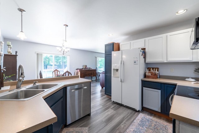 6615 Cavin Dr, Wausau, WI 54401 - kitchen with white fridge with ice dispenser, stainless steel dishwasher, a chandelier, white cabinetry, and hanging light fixtures